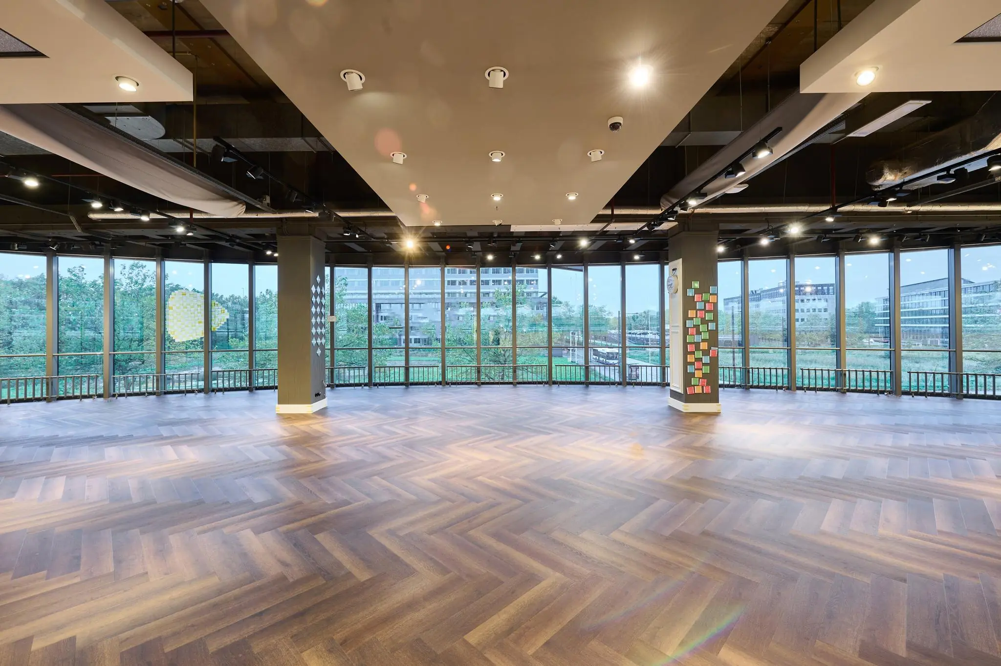 Lichte, ruime zaal met houten visgraatvloer en hoge ramen aan de Johan Huizingalaan.